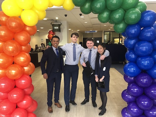 People and balloons under arch